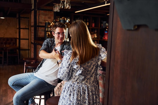 joven, con, mujer, gente, en, ropa casual, sentado, en, el, pub