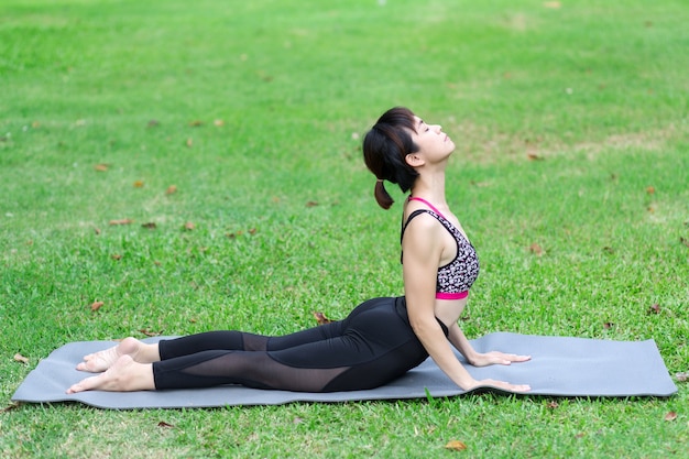 Joven mujer haciendo yoga en el parque