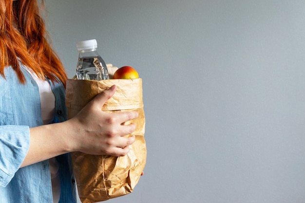 Foto joven mujer hermosa celebración llevar bolsa de papel de alimentos saludables desde la entrega