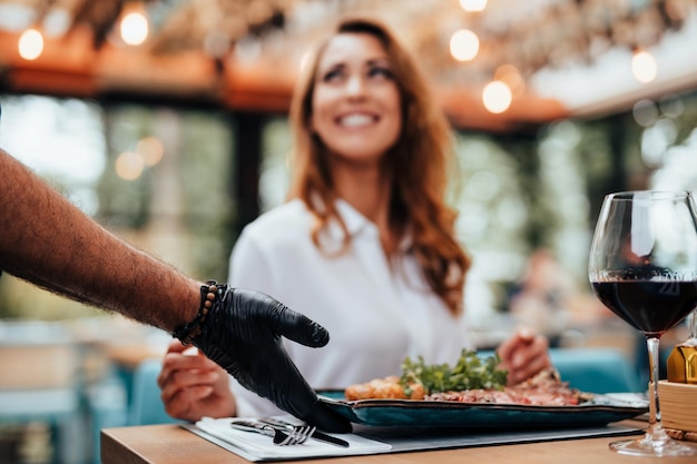 Joven mujer hermosa y feliz disfrutando de una deliciosa comida en un lujoso restaurante.