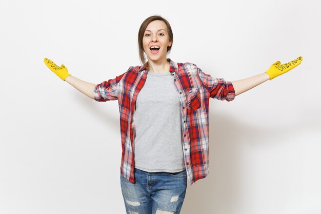 Joven mujer hermosa llena de alegría en ropa casual, construyendo guantes amarillos extendiendo las manos con espacio de copia aislado sobre fondo blanco. Accesorios para habitación de apartamento de renovación. Reparar el concepto de hogar.