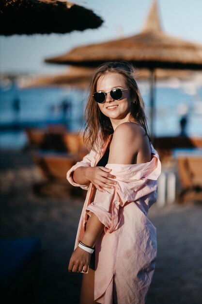 joven mujer hermosa en un resort a la orilla del mar con gafas de sol