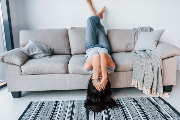 Joven mujer hermosa con ropa informal acostada en la cama y diviértete sola en casa.