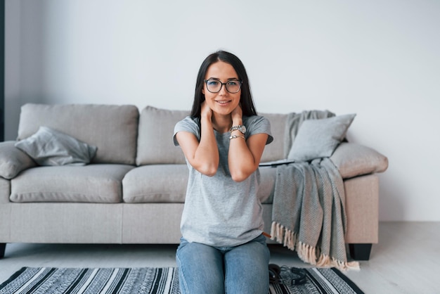 Joven mujer hermosa con ropa informal sentada sola en casa.