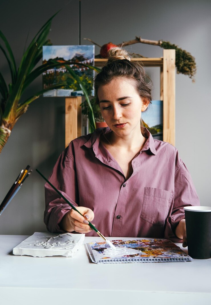 Foto joven mujer hermosa trabaja con relieve de yeso y pintura blanca diy y concepto de pasatiempo