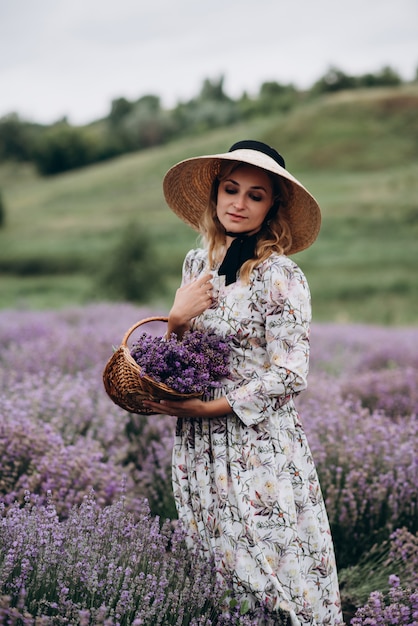 Joven mujer hermosa en un vestido romántico en el campo de lavanda