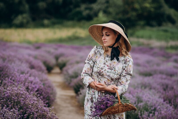 Joven mujer hermosa en un vestido romántico en el campo de lavanda