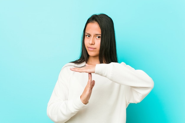 Joven mujer hispana bonita mostrando un gesto de tiempo de espera.