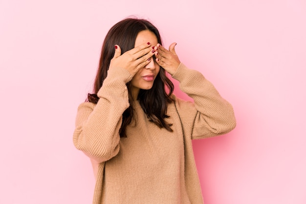 Joven mujer hispana de raza mixta aislada miedo cubrirse los ojos con las manos.