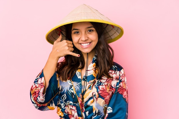 Joven mujer hispana de raza mixta aislada mostrando un gesto de llamada de teléfono móvil con los dedos.