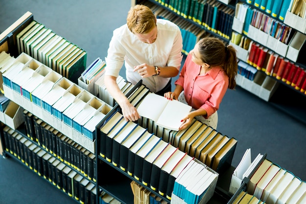 Joven mujer y hombre en la biblioteca