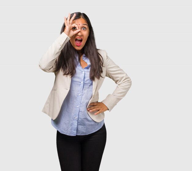 Joven mujer india de negocios alegre y confiada haciendo gesto aceptable, emocionado y gritando