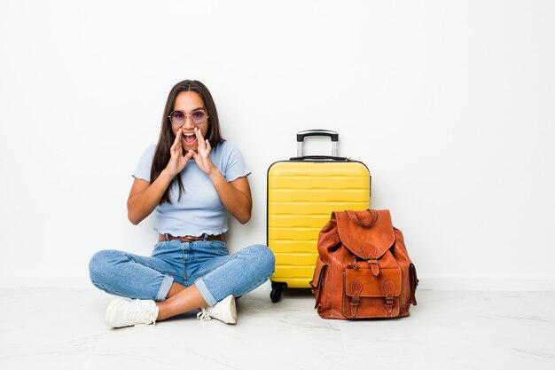 Joven mujer india de raza mixta lista para ir a viajar gritando emocionado al frente.