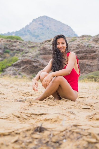 Joven mujer India sentada en la playa