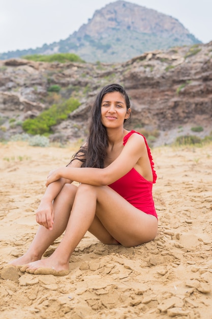 Joven mujer India sentada en la playa