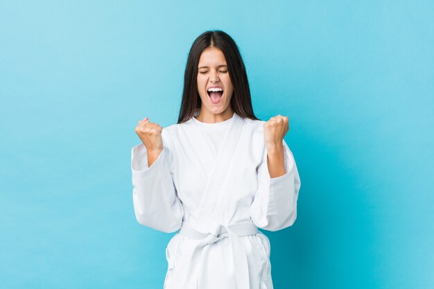 Joven mujer de karate animando despreocupada y emocionada