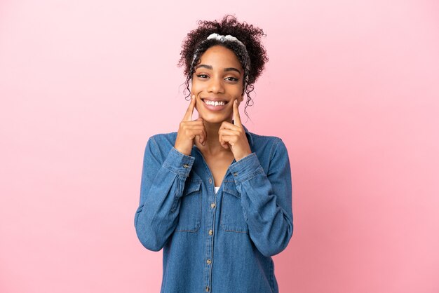 Joven mujer latina aislada sobre fondo rosa sonriendo con una expresión feliz y agradable