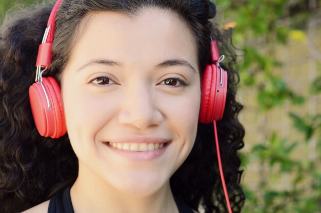 Joven mujer latina con auriculares en un parque.