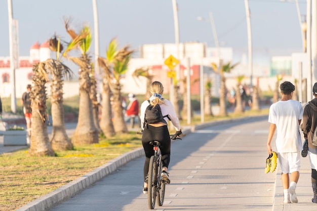 Joven mujer latina en bicicleta en un carril bici al hermoso atardecer