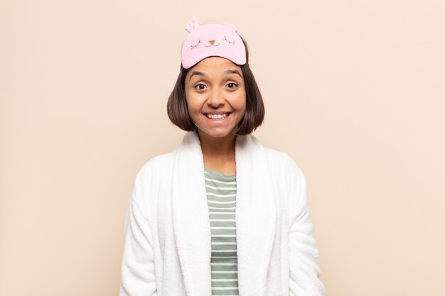 Joven mujer latina que parece feliz y tonta con una amplia, divertida y loca sonrisa y los ojos bien abiertos