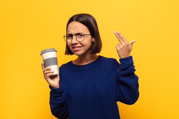 Joven mujer latina que se siente confundida y desconcertada, mostrando que está loco, loco o loco