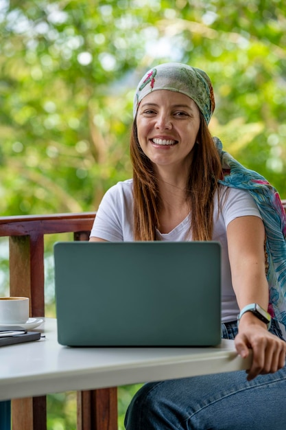 Foto joven mujer latinoamericana trabajando en su computadora portátil en un café al aire libre panamá américa central