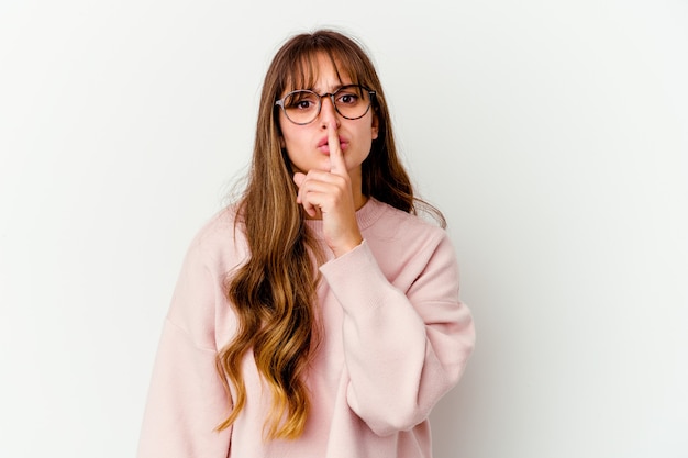 Joven mujer linda caucásica aislada sobre fondo blanco manteniendo un secreto o pidiendo silencio.