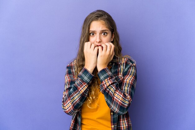 Joven mujer linda caucásica mordiéndose las uñas, nerviosa y muy ansiosa.