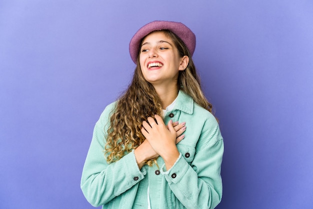 Joven mujer linda caucásica riendo manteniendo las manos en el corazón, concepto de felicidad.