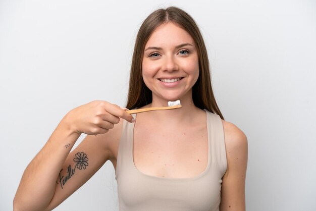 Joven mujer lituana aislada de fondo blanco con un cepillo de dientes y una expresión feliz