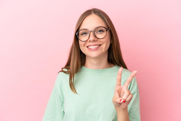 Joven mujer lituana aislada sobre fondo rosa con gafas y haciendo el signo de OK