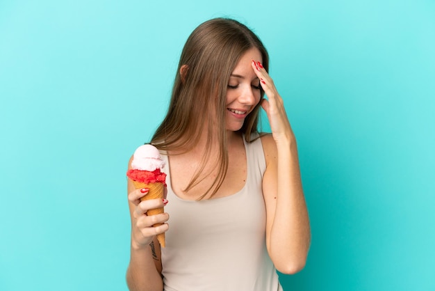 Joven mujer lituana con helado de cucurucho aislado sobre fondo azul riendo