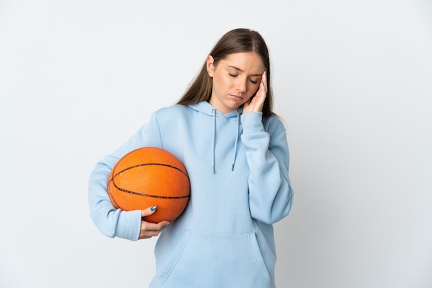 Joven mujer lituana jugando baloncesto aislado sobre fondo blanco con dolor de cabeza