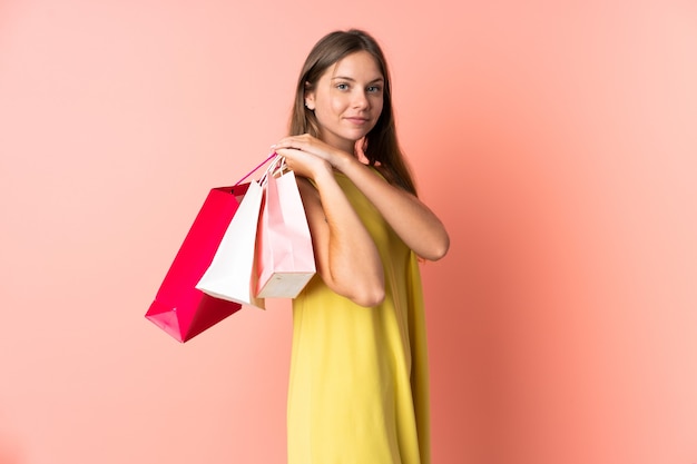 Joven mujer lituana en rosa sosteniendo bolsas de la compra.