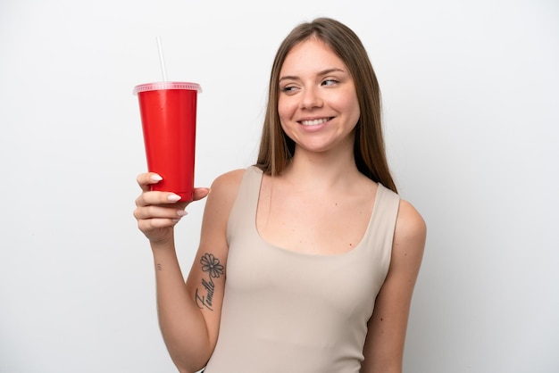 Joven mujer lituana sosteniendo refresco aislado sobre fondo blanco con expresión feliz