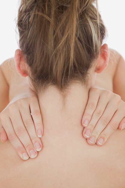 Joven mujer masajeando el cuello