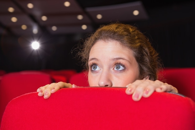 Joven mujer mirando una película de miedo