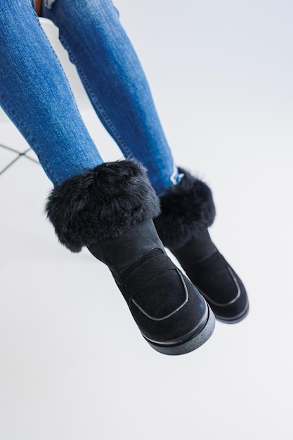 Una joven mujer de moda en elegantes jeans y zapatos de cuero de moda está de pie sobre un azulejo blanco Colección de moda de zapatos de otoño para mujeres Primer plano de piernas femeninas en zapatos