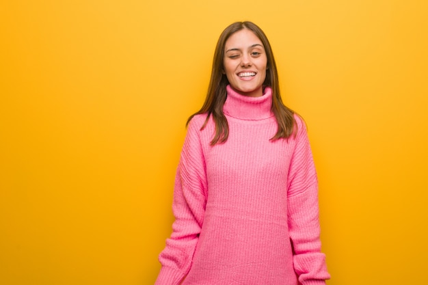 Joven mujer moderna guiñando, divertida, simpática y despreocupada gesto.