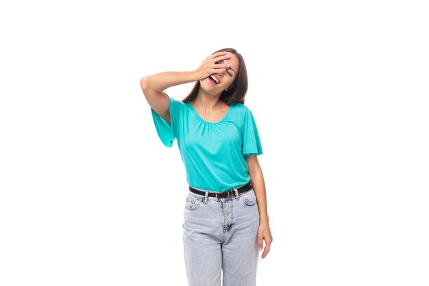 Joven mujer morena caucásica bien arreglada con cabello largo en una camiseta azul aislada en blanco