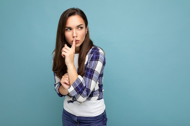 Joven mujer morena hermosa enojada seria con emociones sinceras con camisa a cuadros de moda de pie