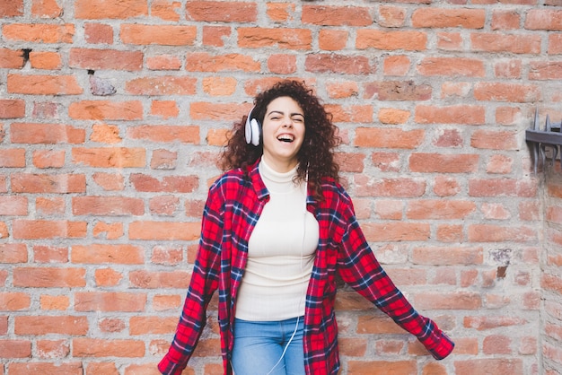 Joven mujer multiétnica escuchando música al aire libre divirtiéndose