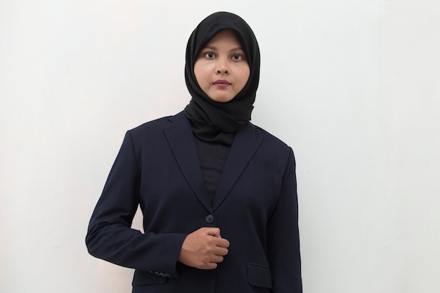 Joven mujer musulmana asiática con pañuelo en la cabeza sonríe con los brazos cruzados