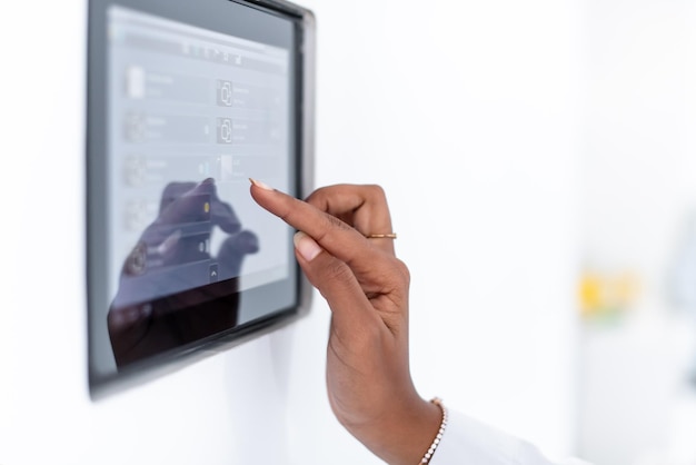 Foto joven mujer musulmana moderna africana que usa un sistema de control de pantalla de inicio inteligente