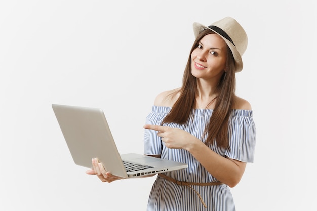 Joven mujer muy feliz en vestido azul, sombrero trabajando en equipo portátil moderno aislado sobre fondo blanco. Personas independientes de negocios, estilo de vida, concepto de compras en línea. Oficina móvil. Publicidad