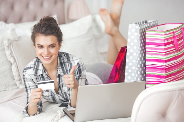 Joven mujer muy hermosa haciendo compras en línea en casa