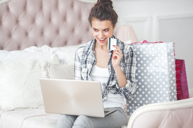 Joven mujer muy hermosa haciendo compras en línea en casa