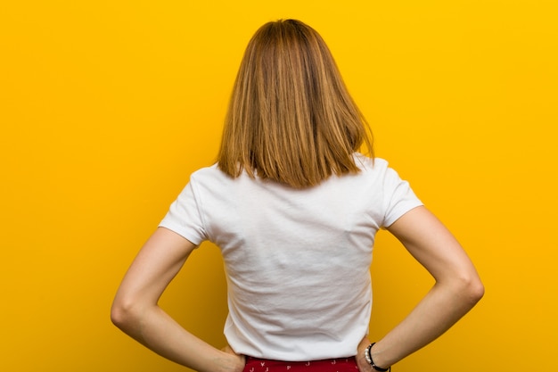 Joven mujer natural desde atrás, mirando hacia atrás.