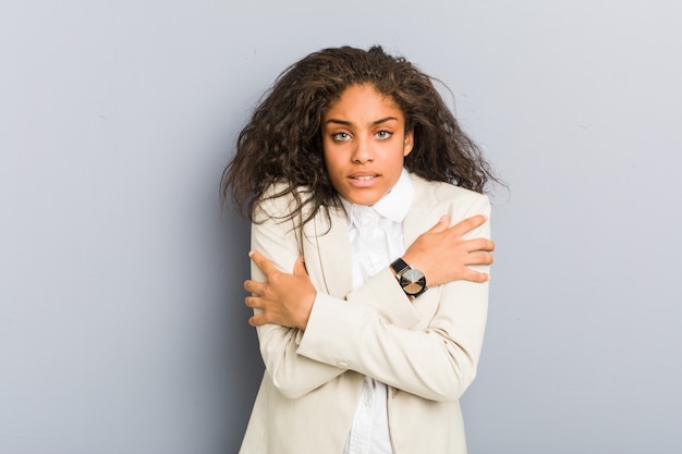 Joven mujer de negocios afroamericano va frío debido a la baja temperatura