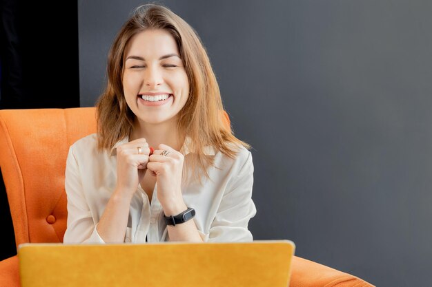 Foto una joven mujer de negocios alegre está feliz por su logro laboral sonriendo con los ojos cerrados hermosa